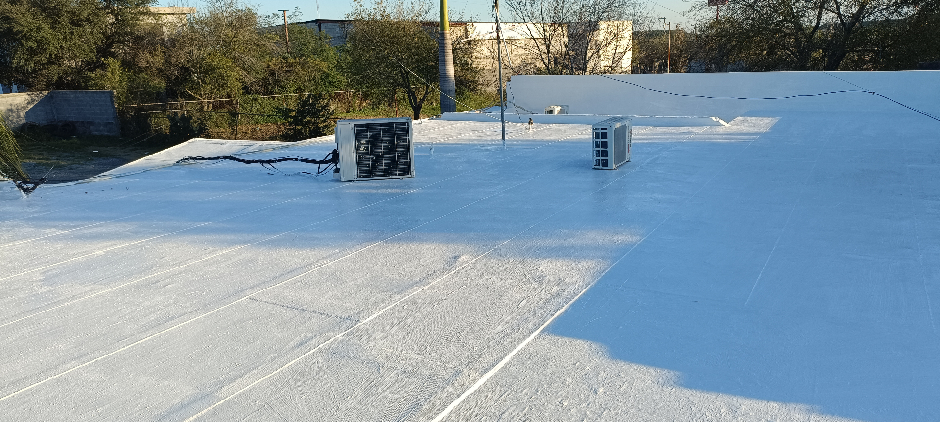 Nave comercial con impermeabilizante blanco sobre gran superficie